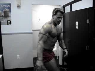 Bodybuilder poses in public bathroom
