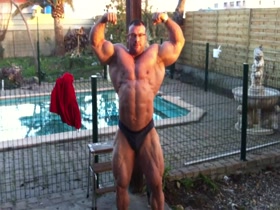 Massive Bodybuilder posing in the garden
