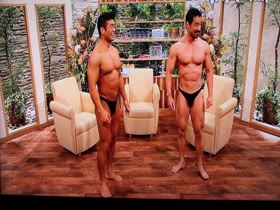 Bodybuilders + guy on Muscle suit on TV