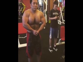 Super massive Asian bodybuilder pumps up sweaty hairy pecs
