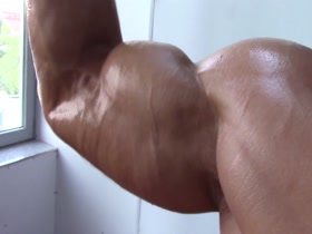 Ripped guy pumps up biceps