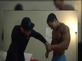 Young and massive bodybuilder flexes for his friend