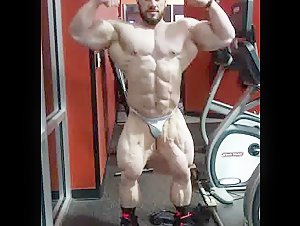 Huge bodybuilder posing at the gym