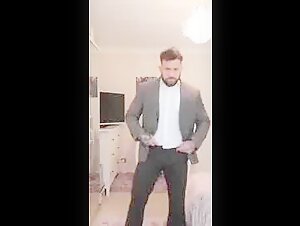 Suited british bodybuilder strips and jerks